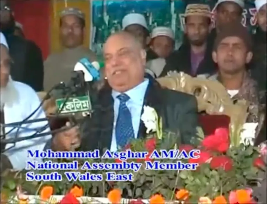 Television footage of a speaker in a suit, captioned Mohammad Asghar AM, National Assembly Member, South Wales East